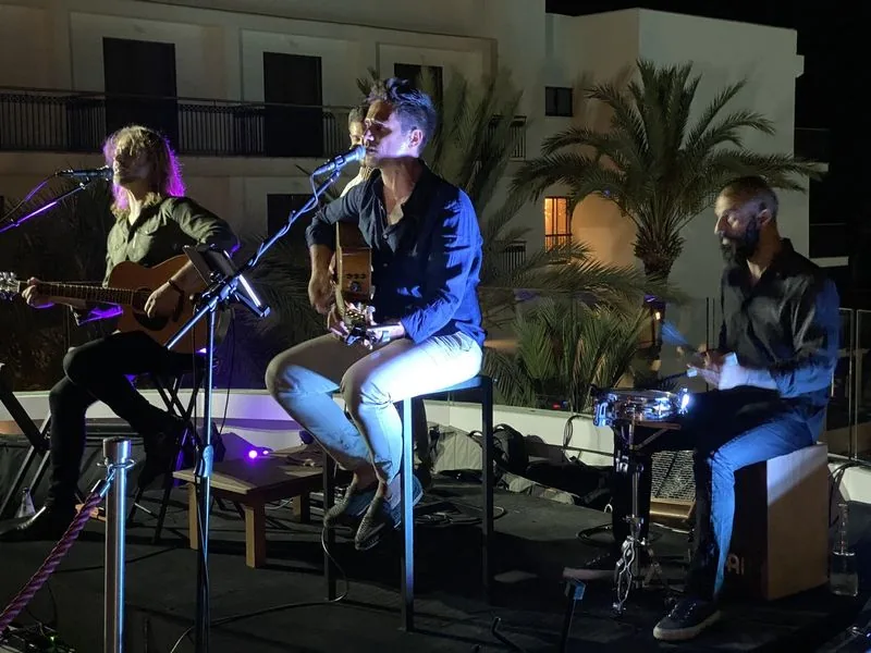 Stelios Antoniou performing with his band at an outdoor evening venue